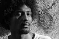 Expressive monochrome portrait of a man with textured hair and beard in São Paulo.